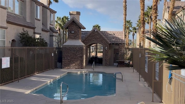 community pool with a patio and fence