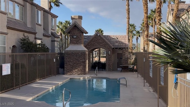 pool with a patio and fence