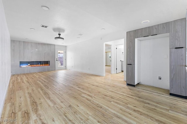 unfurnished living room featuring light wood finished floors and a fireplace