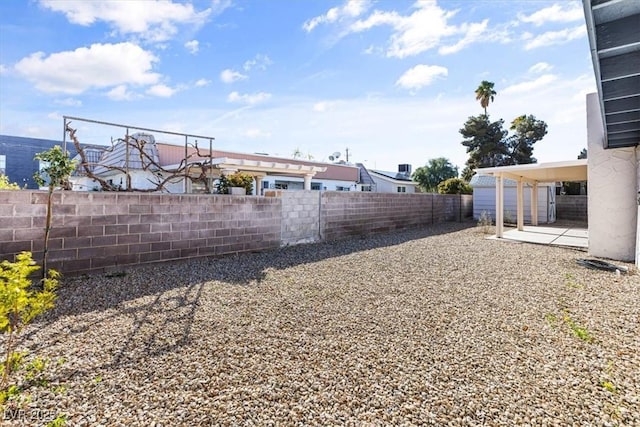 view of yard featuring a shed, a patio, an outdoor structure, and a fenced backyard