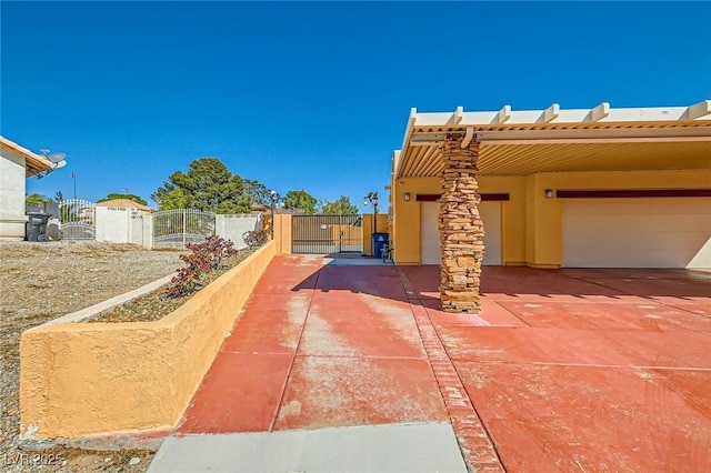 view of patio with a garage, fence, and a gate