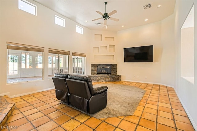 tiled living area featuring baseboards, a ceiling fan, visible vents, and a healthy amount of sunlight