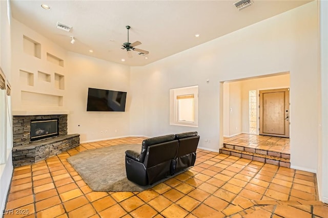 living room with visible vents, light tile patterned flooring, and a ceiling fan