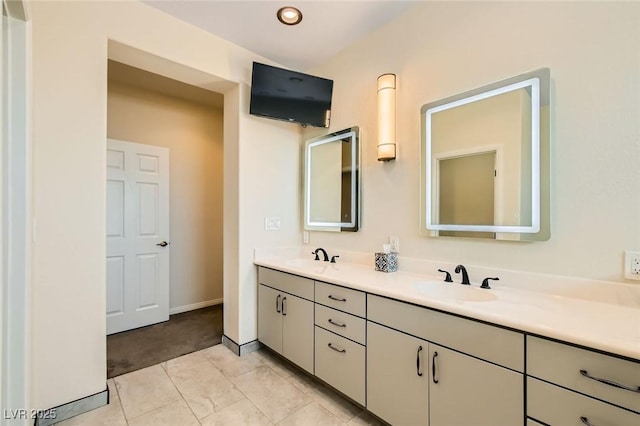 bathroom featuring a sink, baseboards, and double vanity