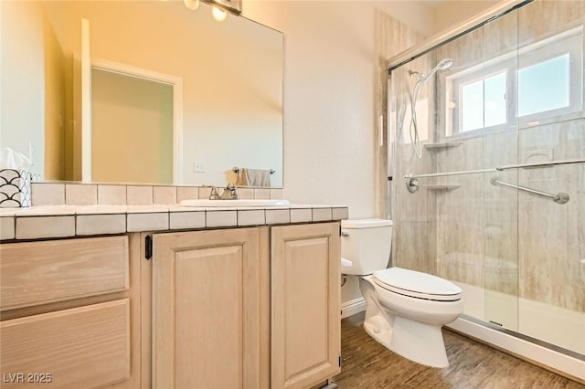 full bathroom featuring vanity, toilet, wood finished floors, and a shower stall