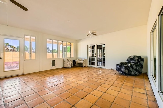 unfurnished sunroom featuring a ceiling fan