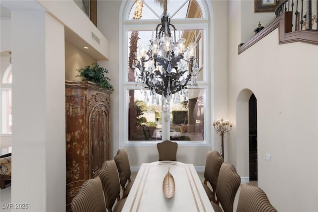 dining space featuring arched walkways, visible vents, and an inviting chandelier