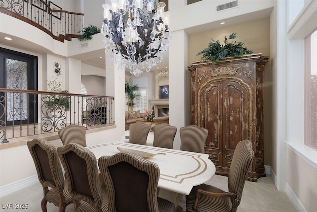 dining space with baseboards, visible vents, a towering ceiling, light carpet, and a notable chandelier