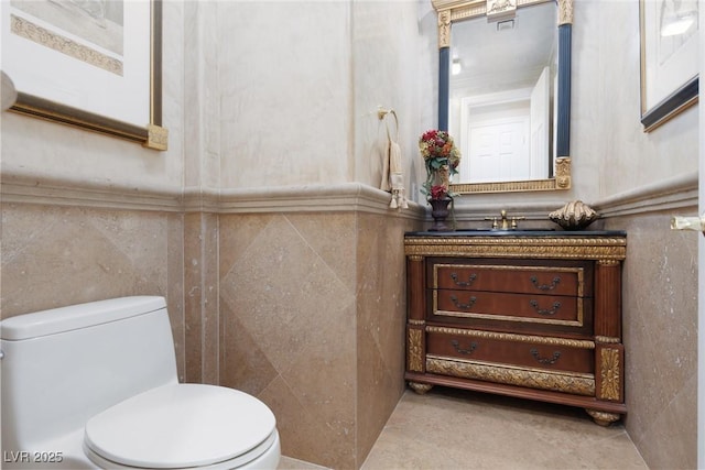 bathroom featuring toilet, tile walls, and vanity