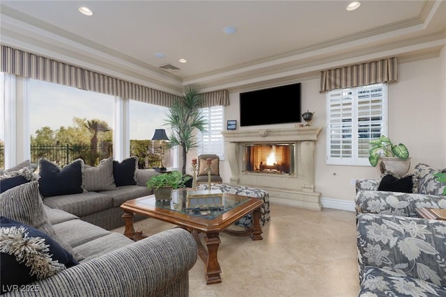 living area with visible vents, baseboards, ornamental molding, a premium fireplace, and recessed lighting