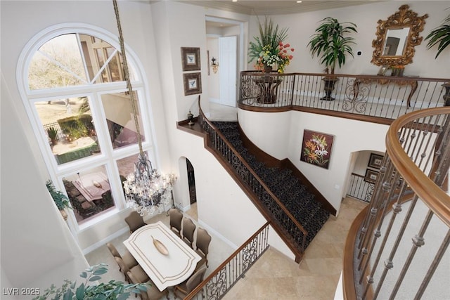 staircase with arched walkways and a towering ceiling