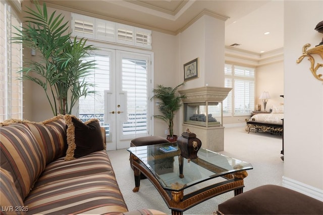 carpeted living room with french doors, baseboards, visible vents, and ornamental molding