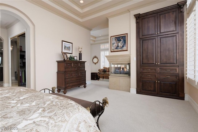 carpeted bedroom featuring baseboards, arched walkways, a multi sided fireplace, and ornamental molding