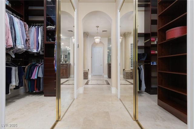 walk in closet with visible vents and arched walkways