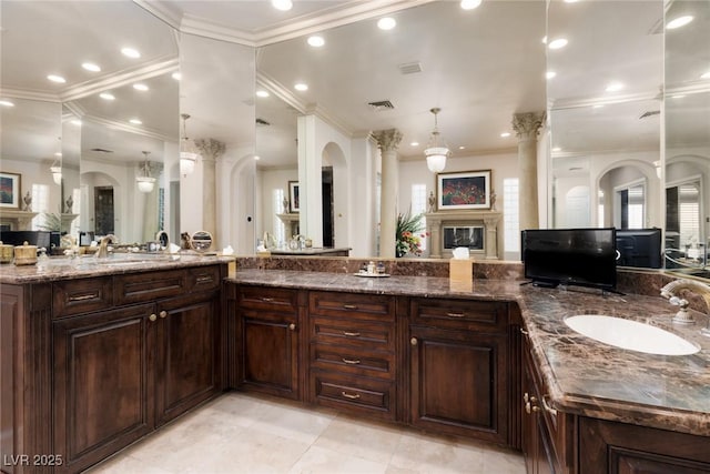 full bath featuring visible vents, ornamental molding, a sink, a glass covered fireplace, and recessed lighting