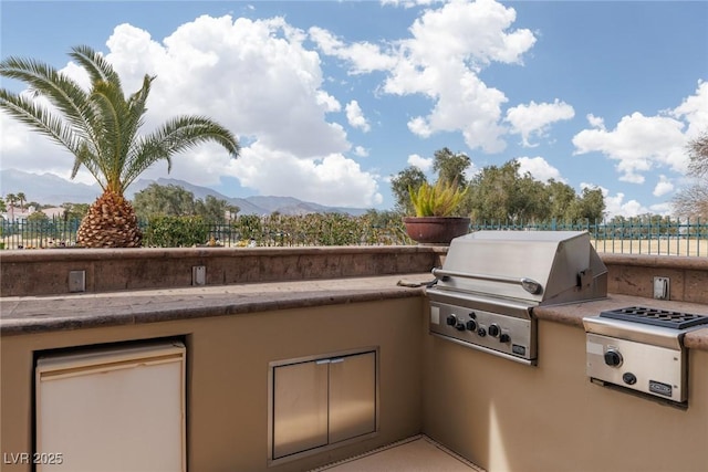 view of patio featuring area for grilling, a mountain view, and fence