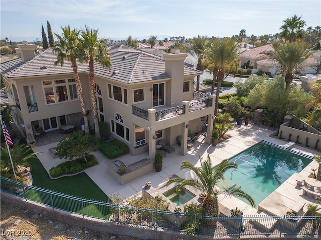 back of house with a patio, a jacuzzi, a fenced backyard, and a chimney