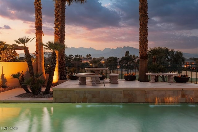 view of swimming pool with a mountain view, a patio area, a fenced in pool, and fence