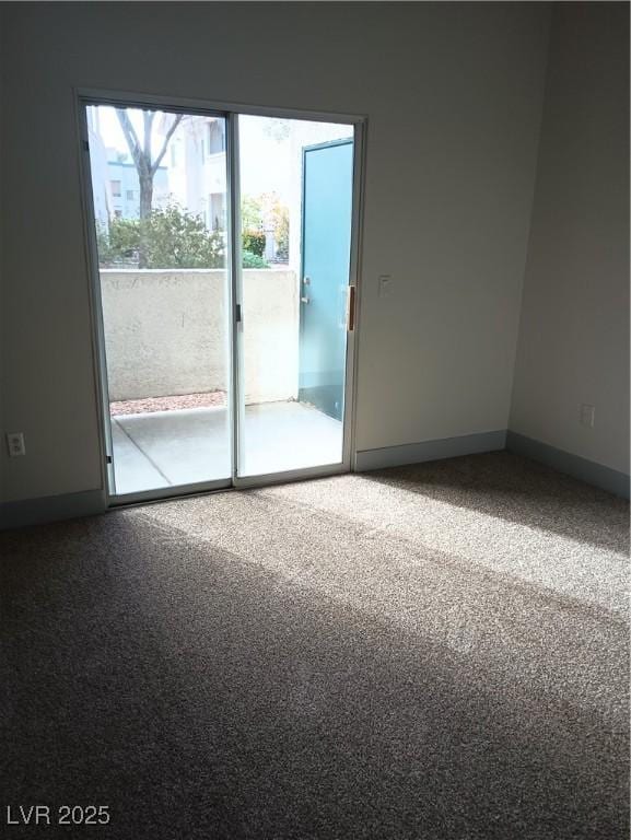 spare room with baseboards and carpet floors