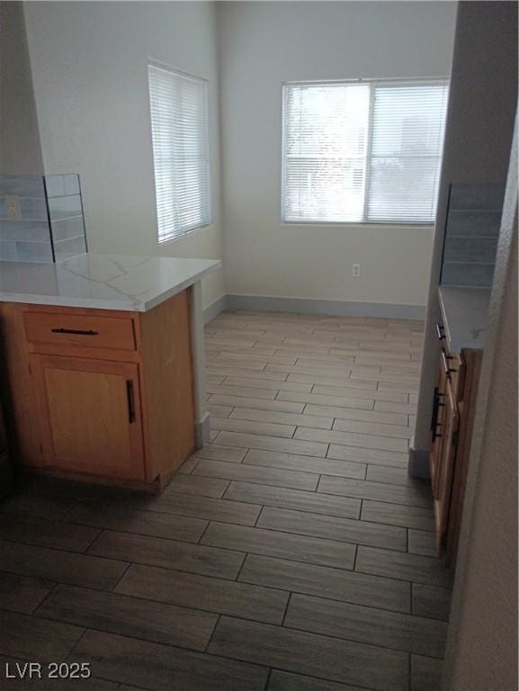 kitchen with light countertops, baseboards, and wood tiled floor