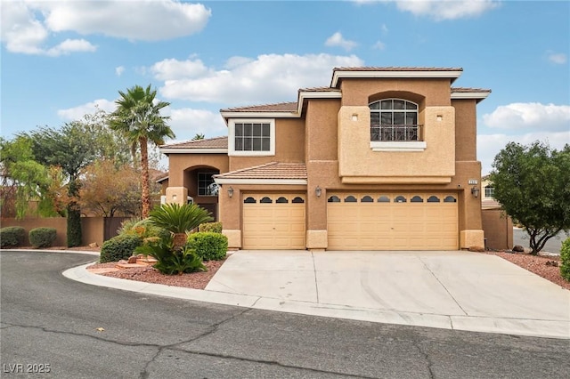 mediterranean / spanish-style home featuring stucco siding, a tile roof, fence, concrete driveway, and a garage