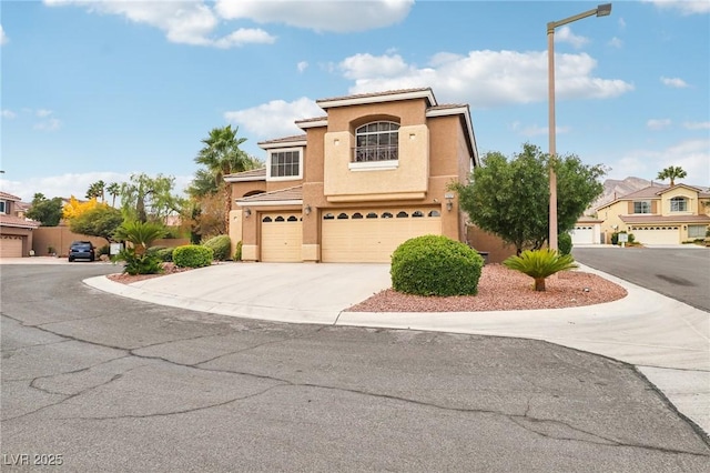 mediterranean / spanish-style house with stucco siding, a tiled roof, concrete driveway, and a garage