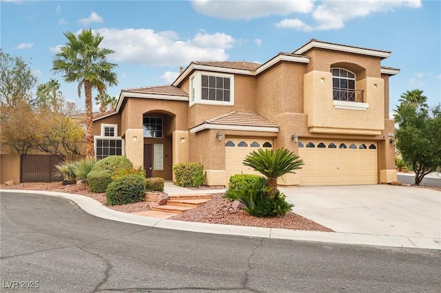 mediterranean / spanish-style home with a garage, fence, driveway, and stucco siding