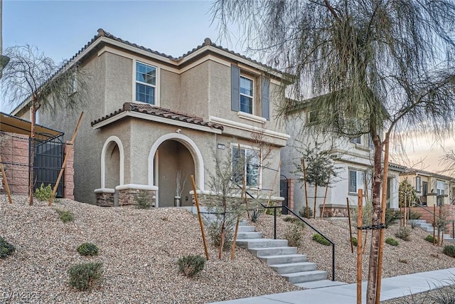 view of front of house with a tile roof and stucco siding