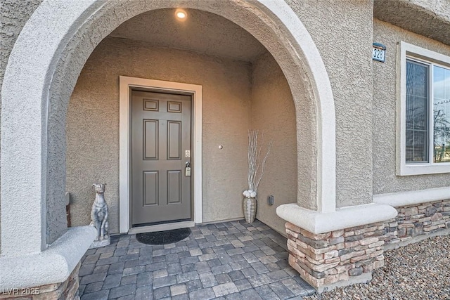 view of exterior entry with stucco siding