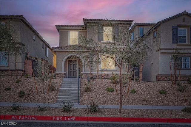 view of front facade featuring stucco siding and a tiled roof