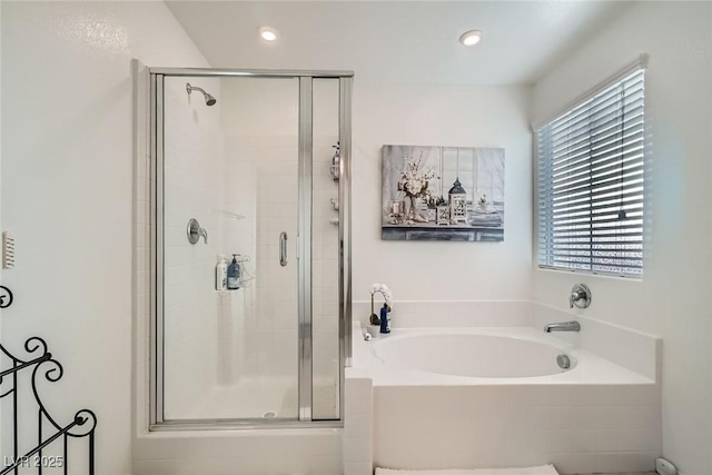 bathroom featuring a shower stall, a garden tub, and recessed lighting