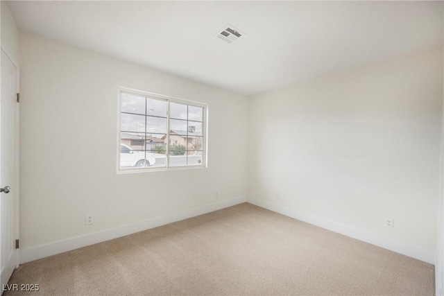 empty room featuring visible vents, light carpet, and baseboards