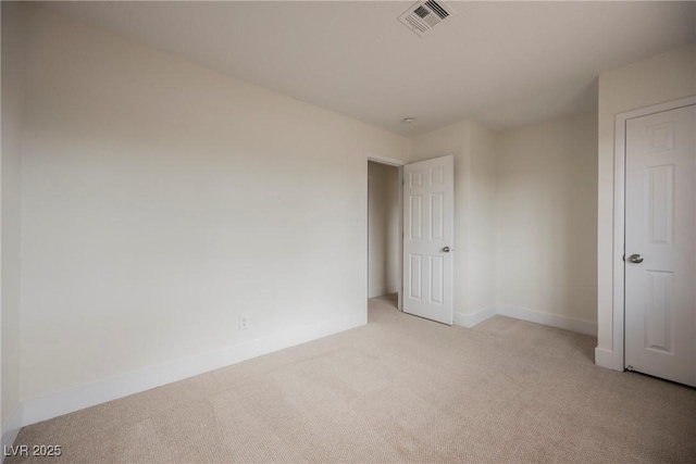 unfurnished room with baseboards, visible vents, and light carpet