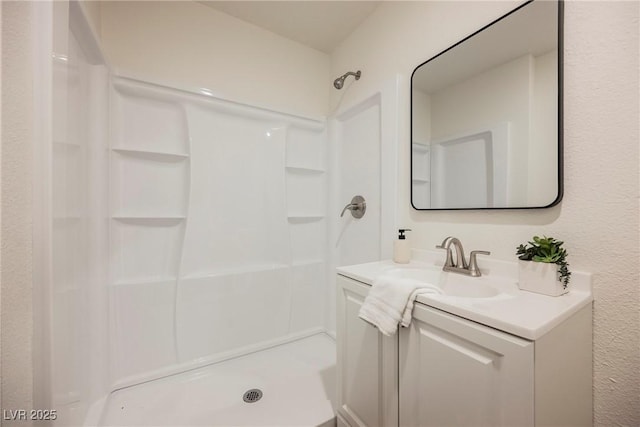 full bath featuring a shower and vanity