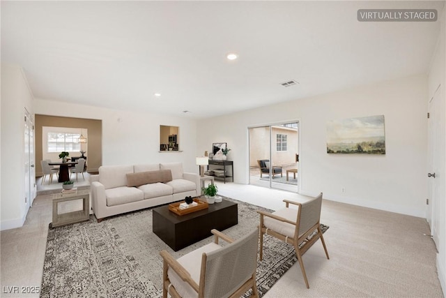 living room featuring recessed lighting, visible vents, baseboards, and light colored carpet