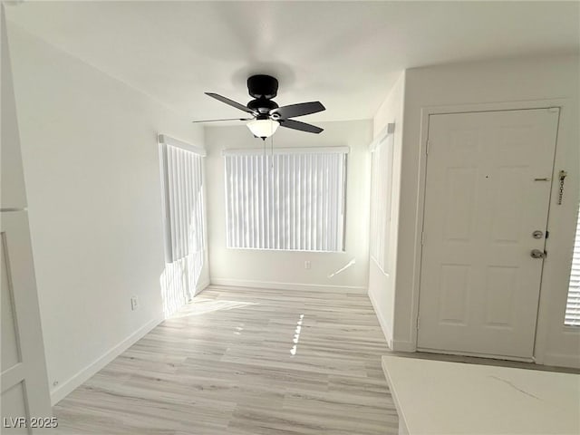 foyer with baseboards, light wood-style floors, and ceiling fan