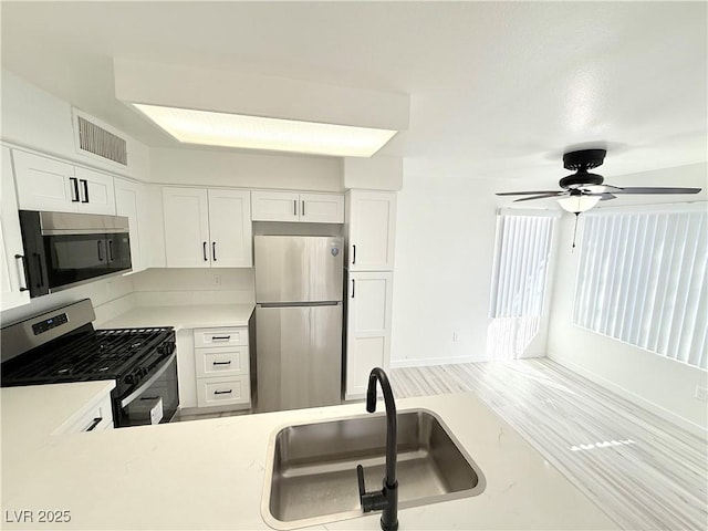 kitchen featuring light countertops, white cabinets, visible vents, and stainless steel appliances