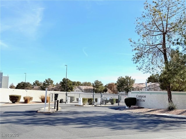 view of road with a gate, curbs, and a gated entry