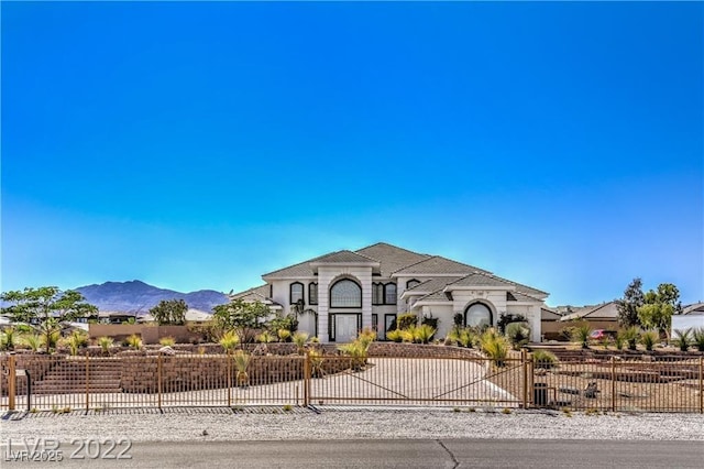 view of front of house featuring a fenced front yard and a mountain view