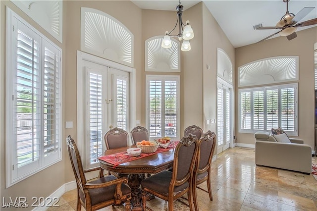 dining room featuring a high ceiling, baseboards, and a wealth of natural light