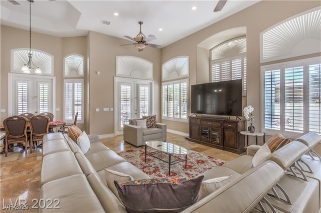 living room featuring a wealth of natural light, french doors, and ceiling fan