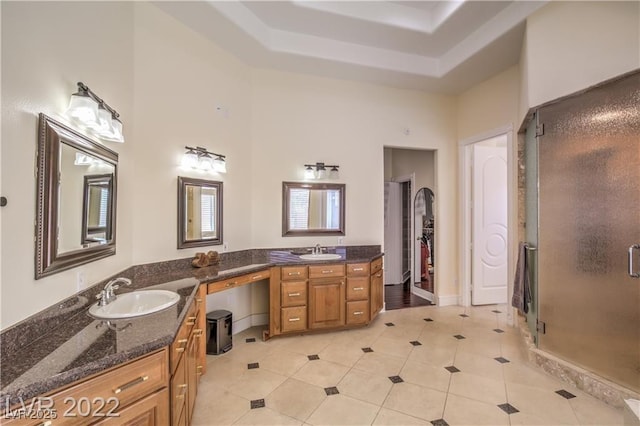 full bath featuring tile patterned flooring, a shower stall, a towering ceiling, vanity, and a raised ceiling