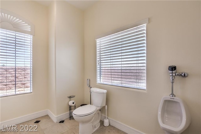 half bathroom with tile patterned floors, baseboards, and toilet