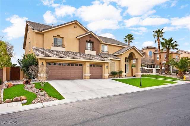 view of front of house featuring stucco siding, an attached garage, concrete driveway, and a gate