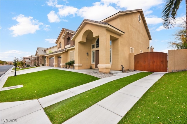 mediterranean / spanish-style home with an attached garage, a front yard, stucco siding, driveway, and a gate