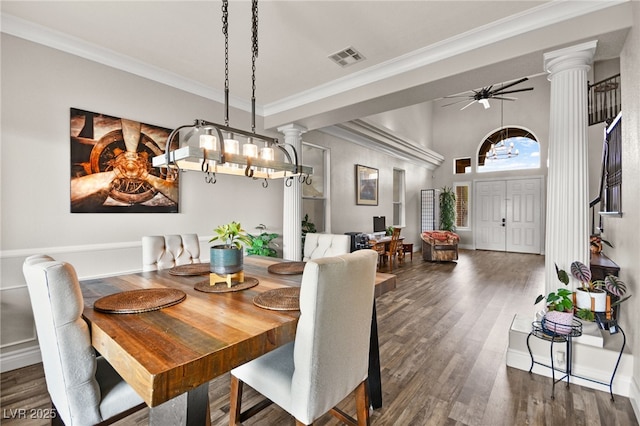 dining space with dark wood-style floors, visible vents, crown molding, and decorative columns