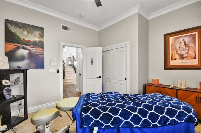 bedroom featuring baseboards, visible vents, carpet floors, ornamental molding, and a closet