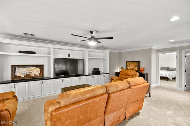 living room featuring built in features, a ceiling fan, visible vents, crown molding, and light colored carpet