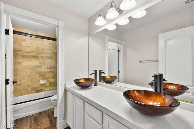 bathroom with a sink, toilet, and wood finished floors