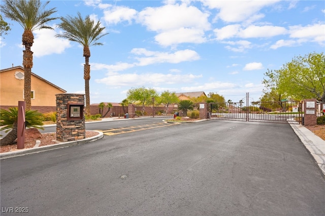 view of street with a gated entry, curbs, and a gate